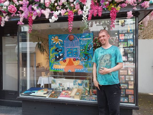 Vincent Bockweg voor zijn schilderij in de etalage van ons nieuwe pand in Baarn